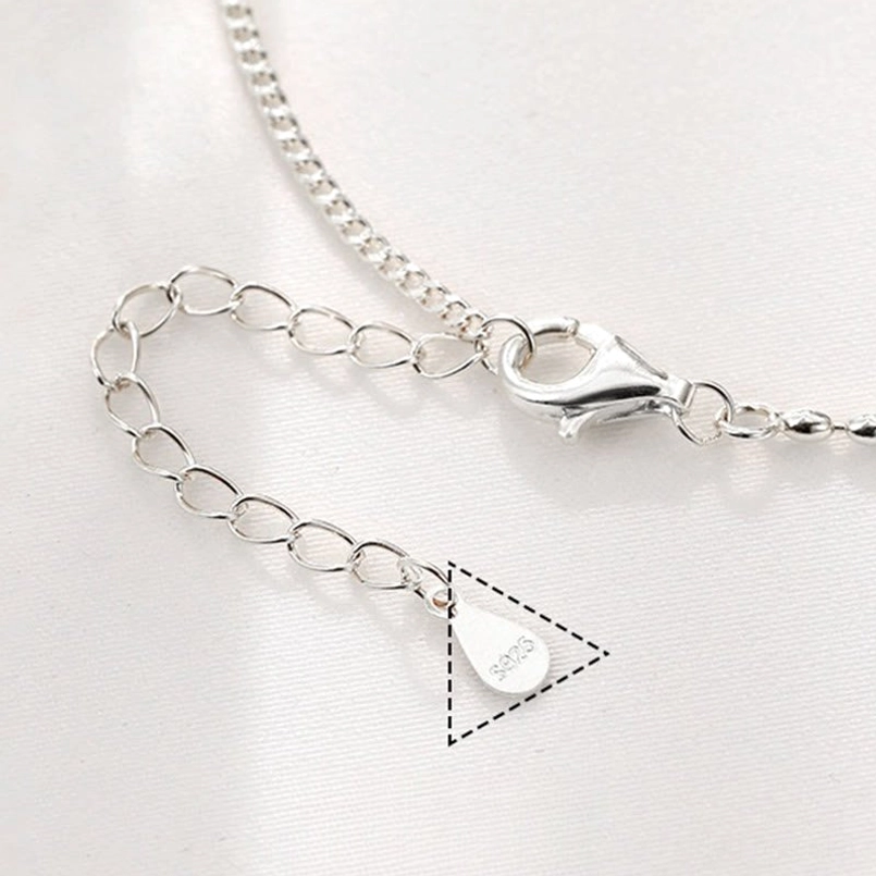 Close-up detail of handcrafted sterling silver beads and red agate stones on blessing anklet