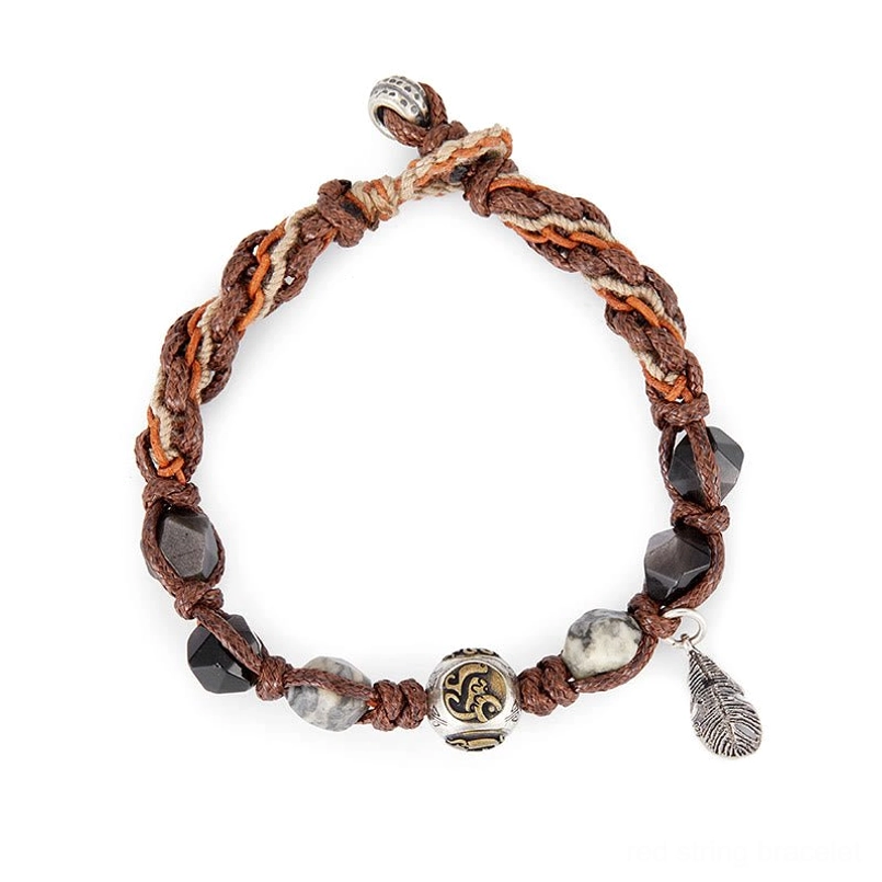 front flat lay view of handmade braided red string bracelet with feather charm
