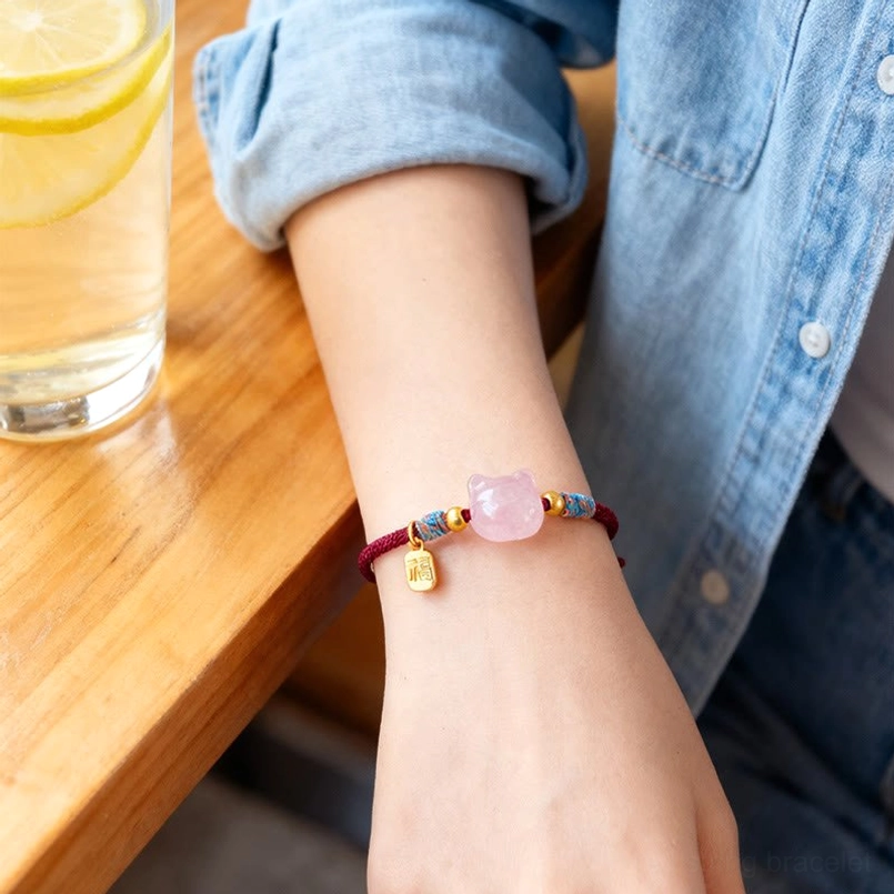 Handmade red string cat protection bracelet with fu character showing intricate braiding and craftsmanship