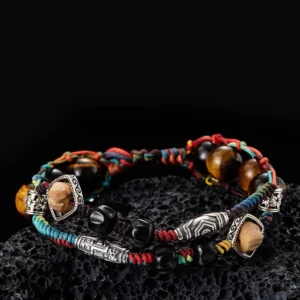 Handmade double layer red string bracelet with tiger's eye 925 sterling silver and bodhi seed on dark volcanic rock