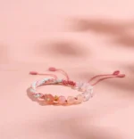 Handmade gradient agate reincarnation knot colorful red string bracelet flat lay on pink background
