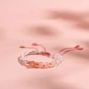 Handmade gradient agate reincarnation knot colorful red string bracelet flat lay on pink background