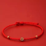 Handmade braided red string bracelet with 925 sterling silver Fu charm front view