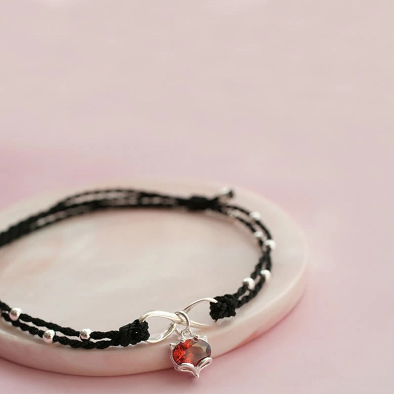 Red string infinity love ankle bracelet flat lay featuring handmade double-layer braid and silver beads