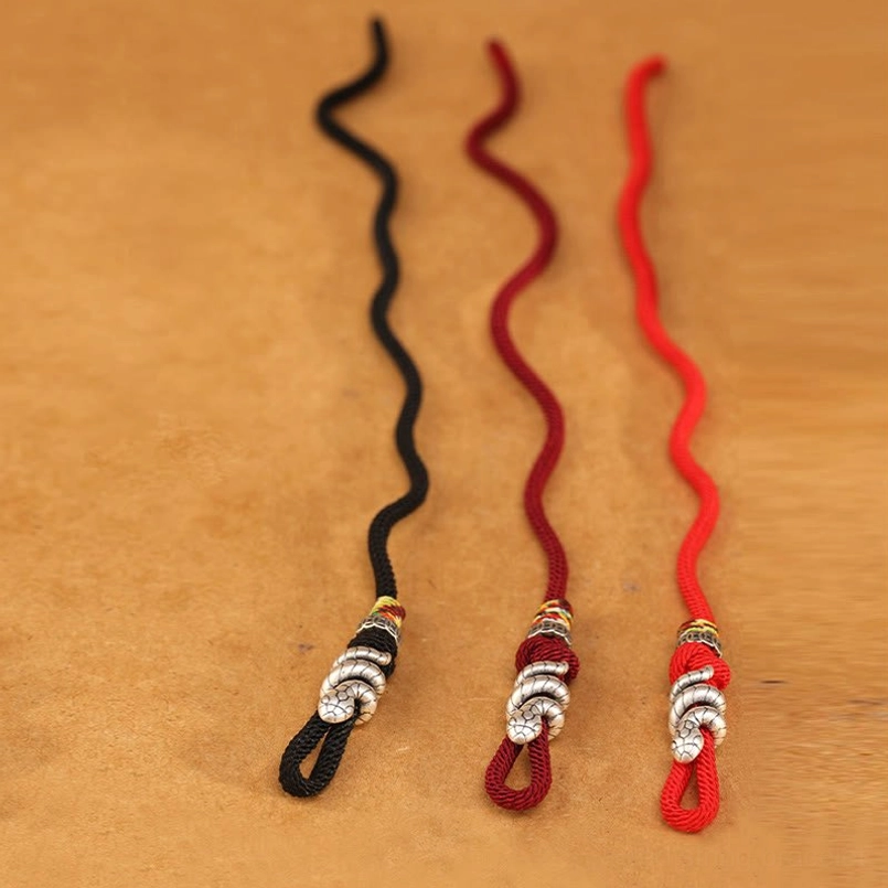 Handmade red string bracelet with braided cord and antique silver snake bead, detail shot