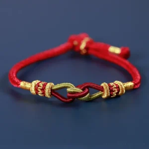 Handmade braided red string bracelet with gold woven knots flat view