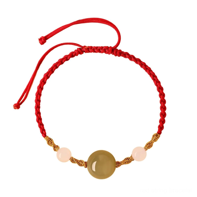 Handmade red string bracelet with jade bead and golden accents, artisan craft