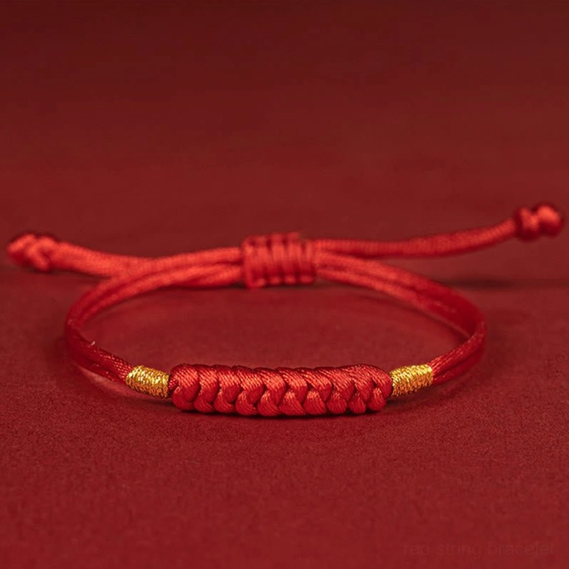 Handmade braided red string lucky knot bracelet side top view on red background