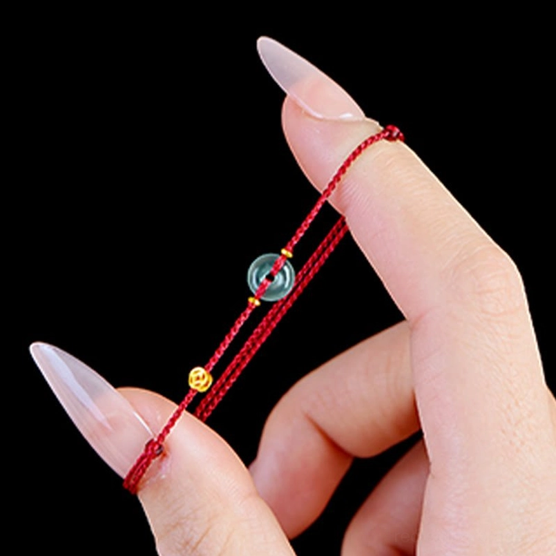 Red string bracelet with peace buckle - handmade artisan craft featuring natural jade and traditional design