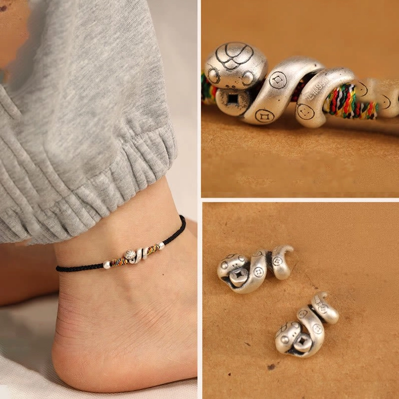 Handmade red string snake anklet close-up showing premium sterling silver charm, colorful bead accents, and natural fiber cord details