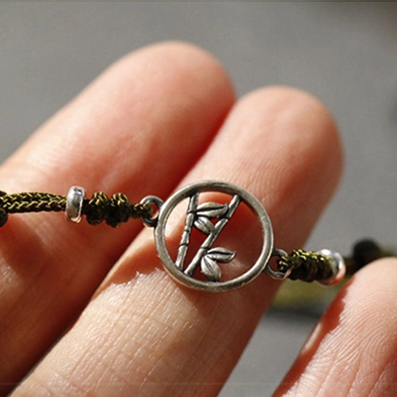 Handmade 925 sterling silver bamboo bracelet featuring protective red cord and natural fiber weave