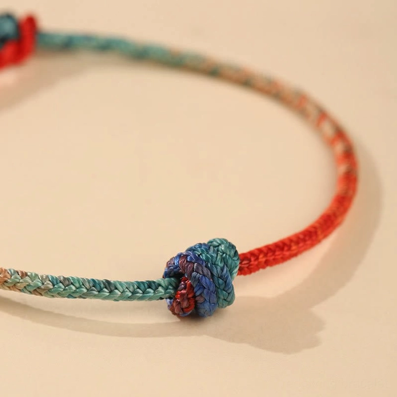 Detailed overhead view of hand-woven bracelet showing dual gradient colors and artisan texture