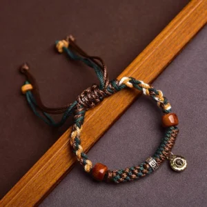 Tibetan bone beads red string bracelet top view on dark brown background
