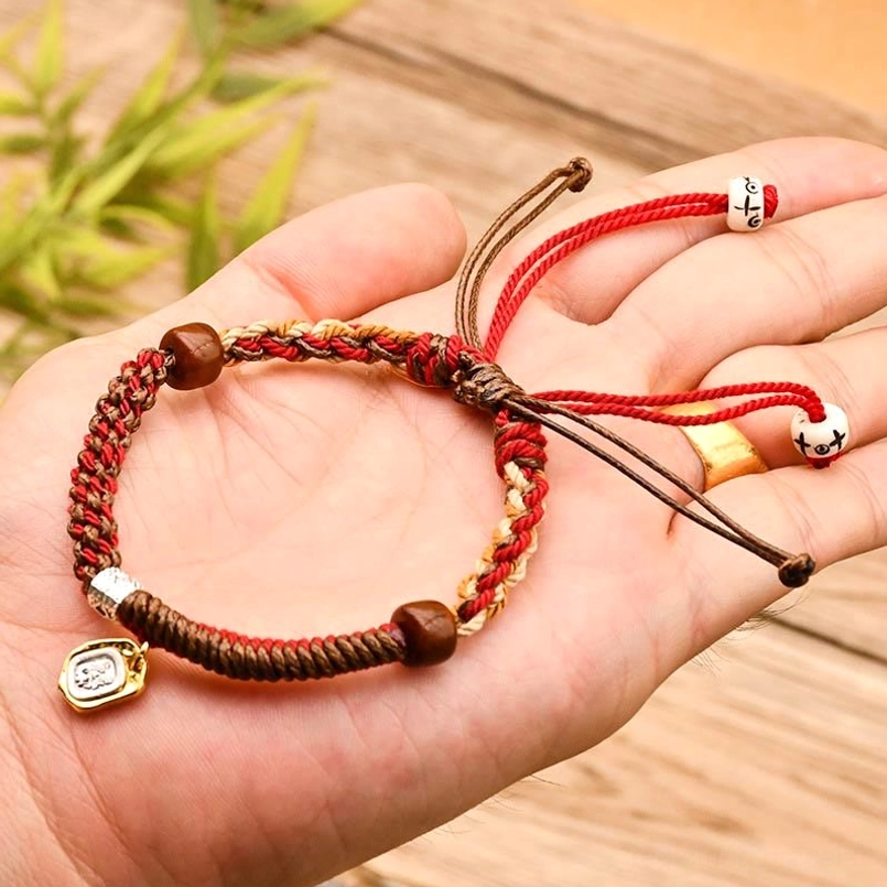 Red Tibetan braided Zakiram goddess of wealth protection bracelet close up detail view