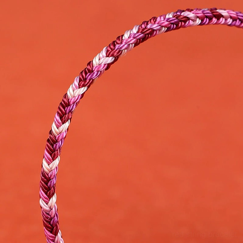 Texture close-up of gradient purple to white twisted woven string bracelet fibers