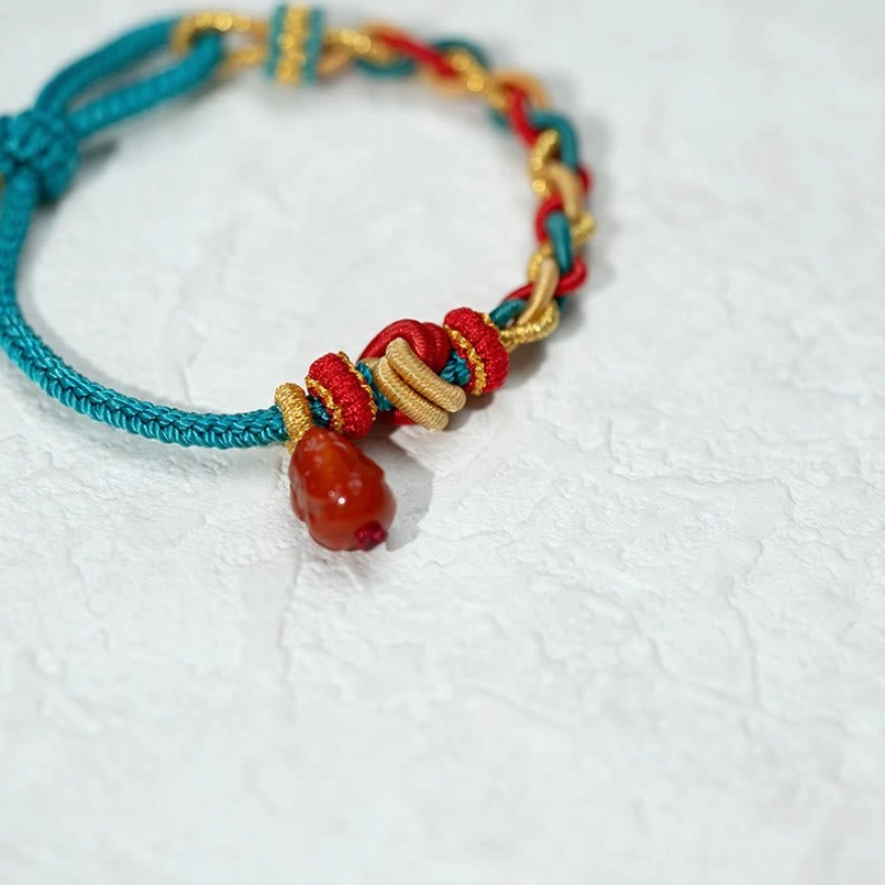 Front flat lay of four-strand braided Pixiu red string bracelet with neat woven knots
