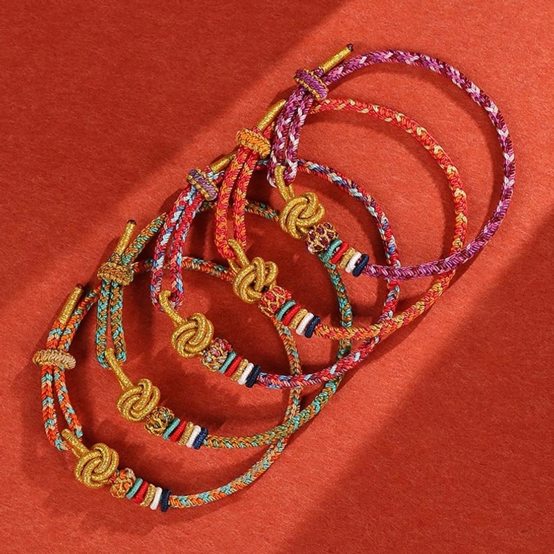 Set of handcrafted colorful string protection bracelets with golden accents in flat lay