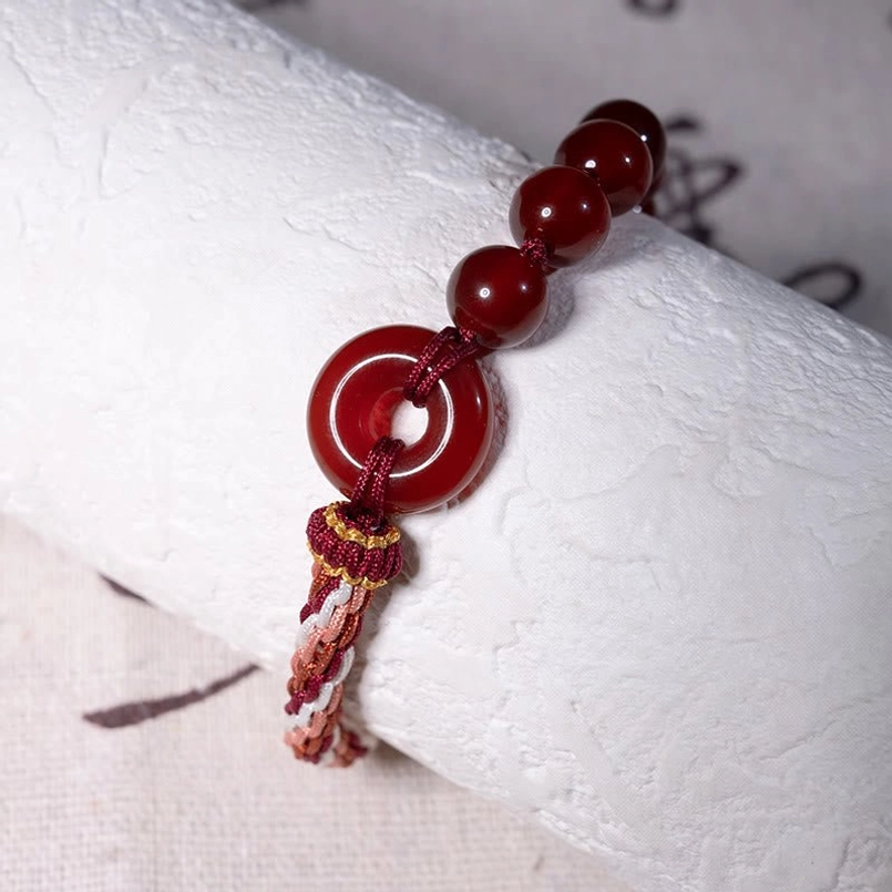 Handwoven Red String Bracelet With Red Agate Peace Buckle Low Angle Shot