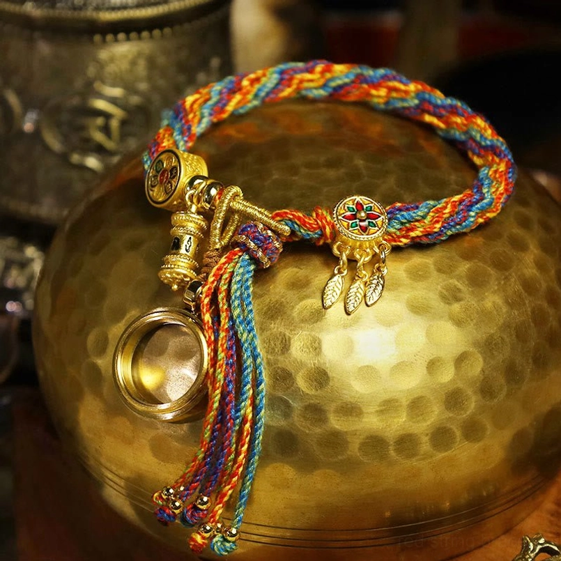 Multicolor braided Tibetan red string bracelet angled shot on brass surface