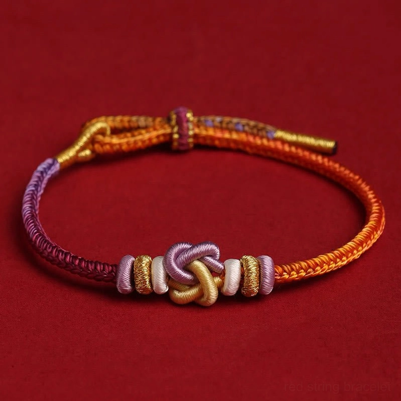 Colorful heart knot protection bracelet flat lay with central decorative knot