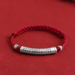 Handmade 999 sterling silver Heart Sutra Om Mani Padme Hum bracelet with dark red woven rope on red background