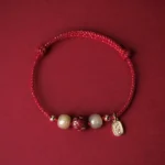 Red string Hetian jade cinnabar lotus lucky bracelet with 14K gold plating - top view flat lay