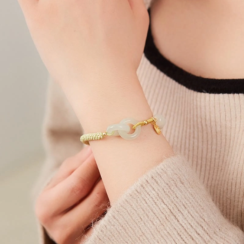 Woman wearing Hetian jade double peace buckle abundance bracelet with fu character pendant lifestyle shot