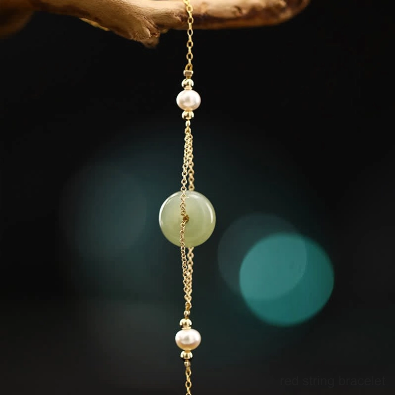 Vertical product shot of hetian jade peace buckle anklet with gold chain and symmetric pearls