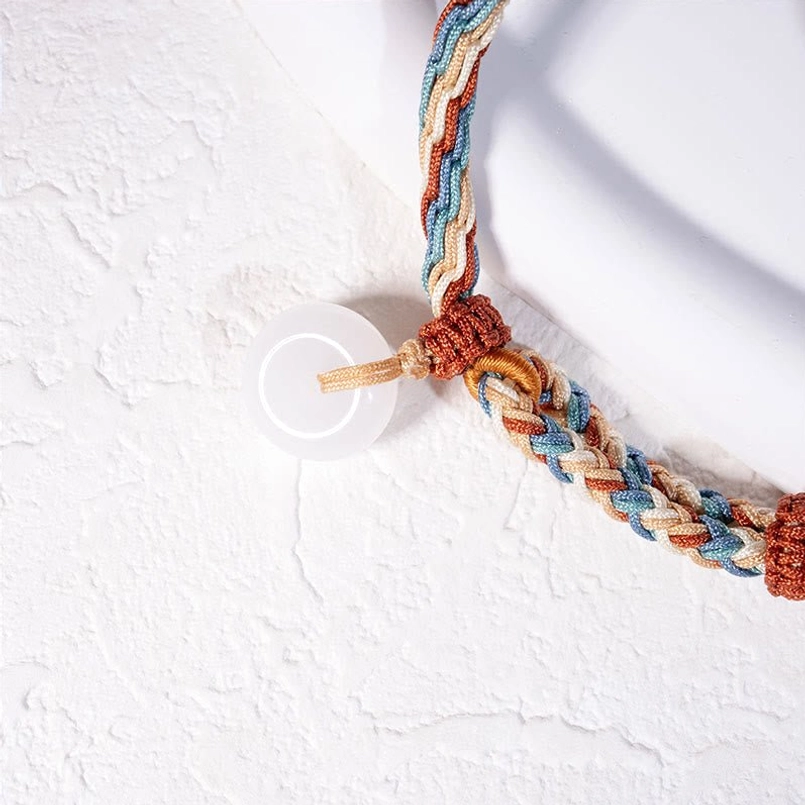 Partial Close Up of Hetian Jade Peace Buckle Braided Bracelet on White Display