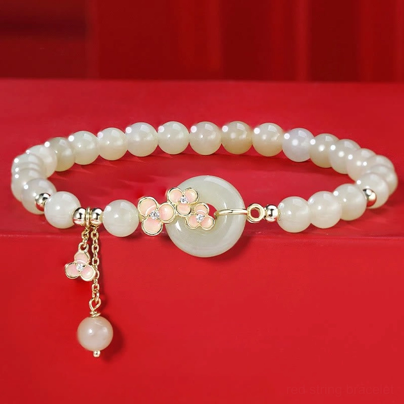 Double-layer Hetian jade peace buckle bracelet with 925 sterling silver and zircon accent on red fabric background