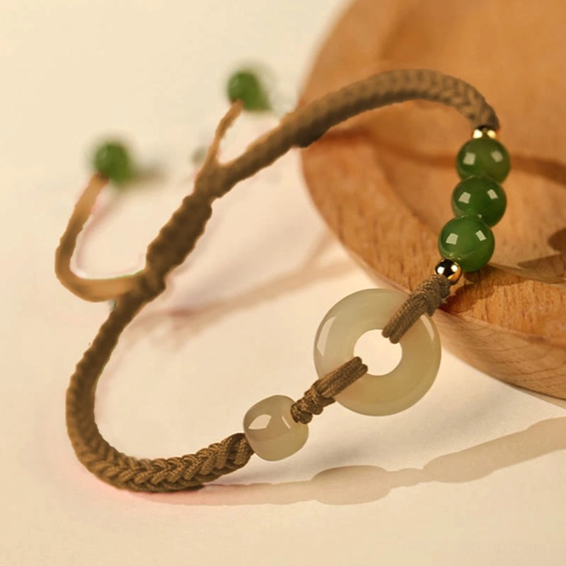 Hetian Jade Peace Buckle Brown String Bracelet Close Up On Wooden Coaster