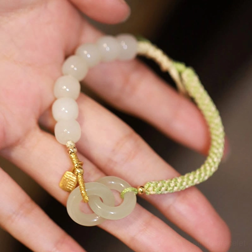 Hetian jade double peace buckle bracelet showing pale green jade rings connected with braided cord