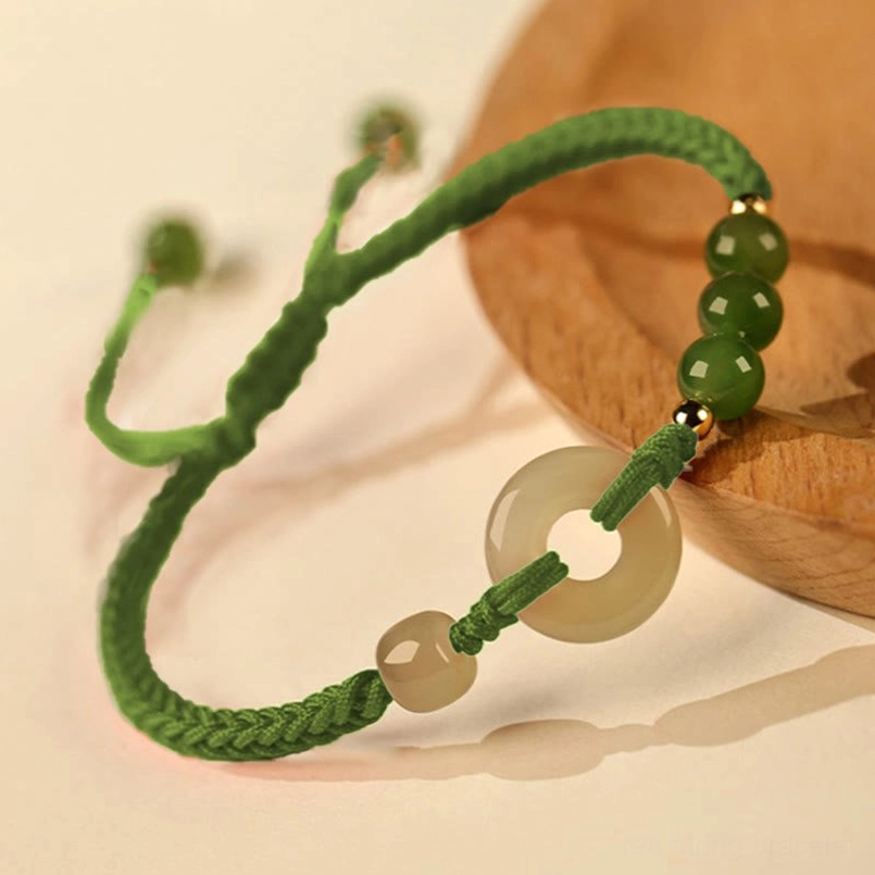 Hetian Jade Peace Buckle Green String Bracelet Close Up On Wooden Coaster