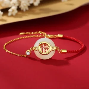 Hetian jade Fu peace buckle red string bracelet top flat lay on red floral background