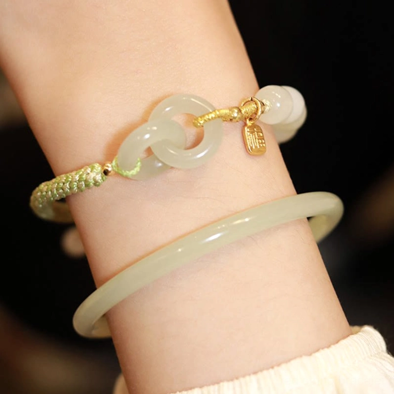 Hetian jade double peace buckle bracelet paired with solid jade bangle on wrist layered jade jewelry set