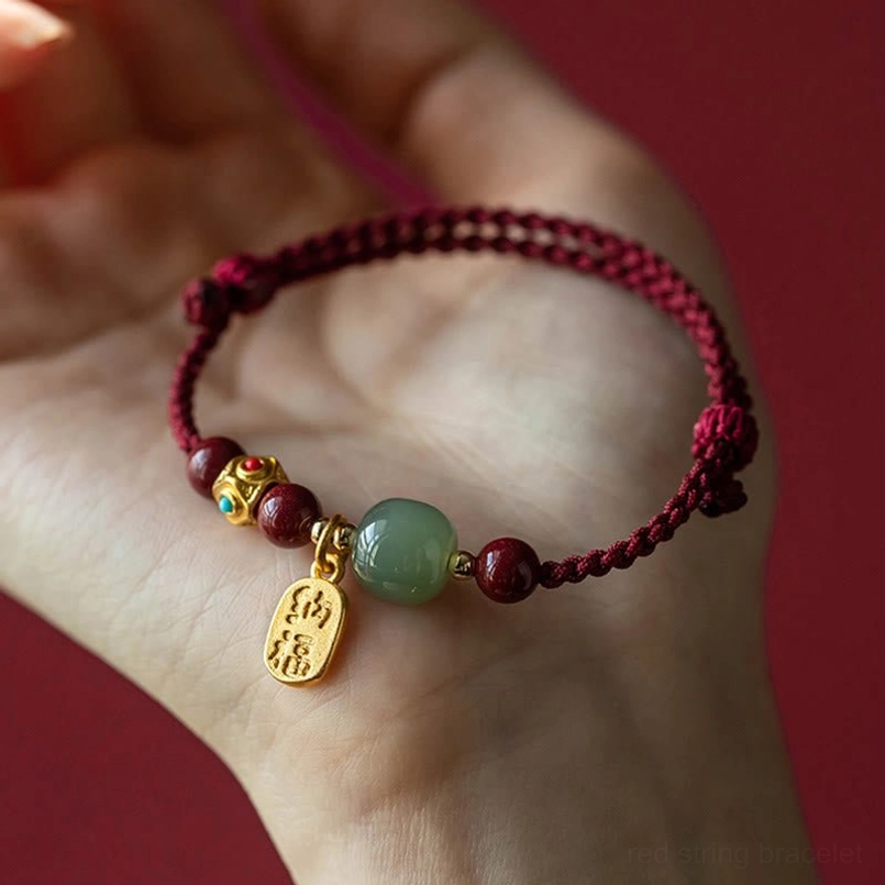 Fortune charm bracelet with white jade and cyan jade held in palm, showing complete design and craftsmanship