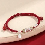 Hetian jade snake year red string protection bracelet with silver charms top view