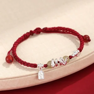 Hetian jade snake year red string protection bracelet with silver charms top view