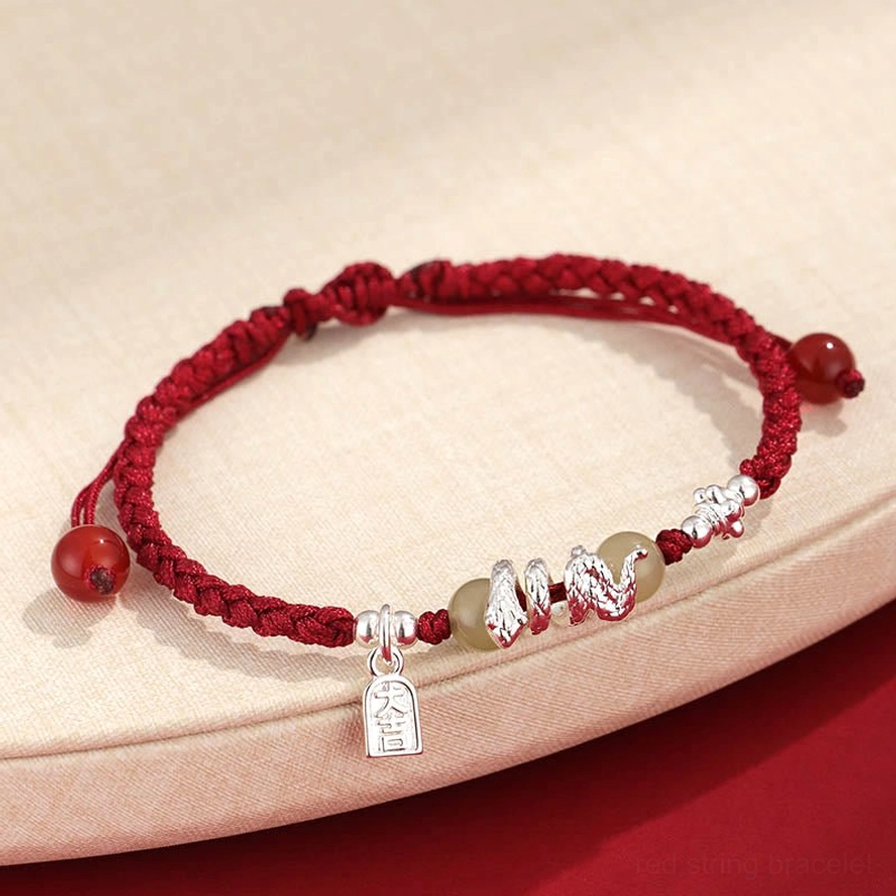 Hetian jade snake year red string protection bracelet with silver charms top view