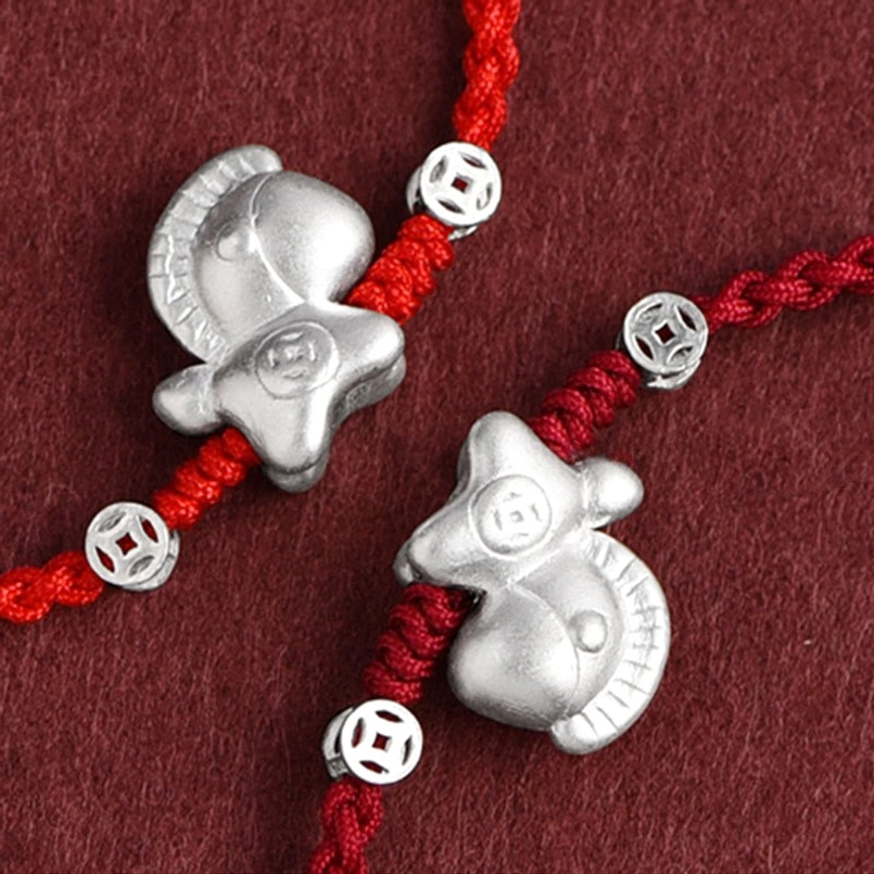Close-up detail of Year of the Horse red string bracelet showing silver horse charm and coin beads