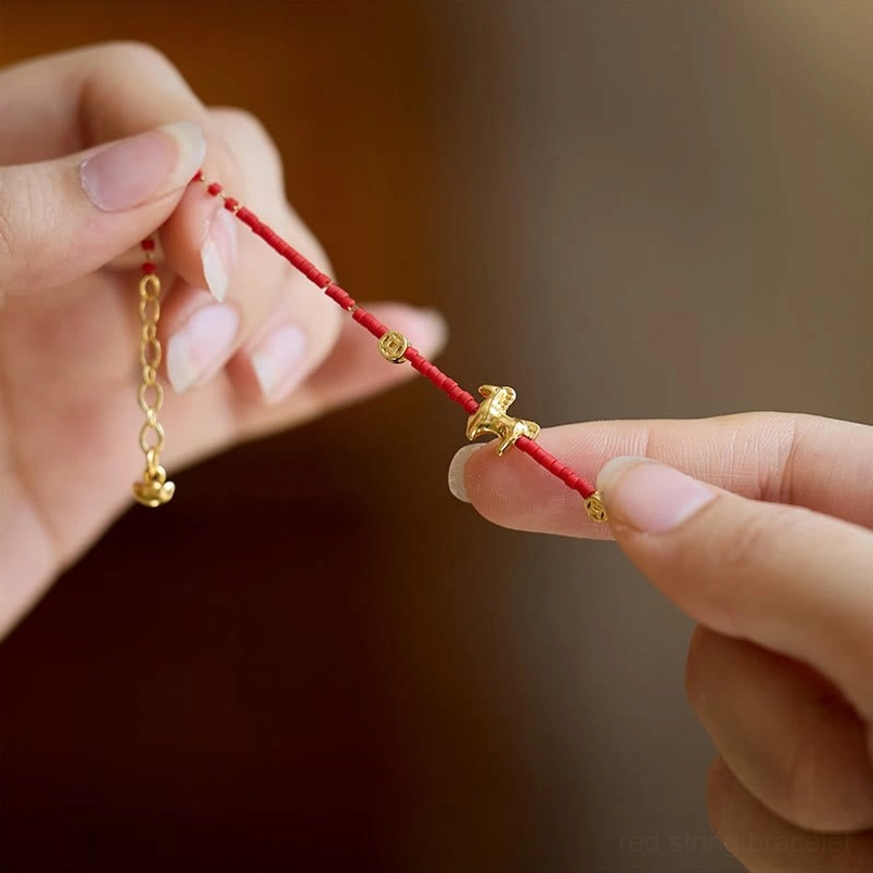 Hand displaying adjustable extension chain and lobster clasp of horse red liuli bracelet