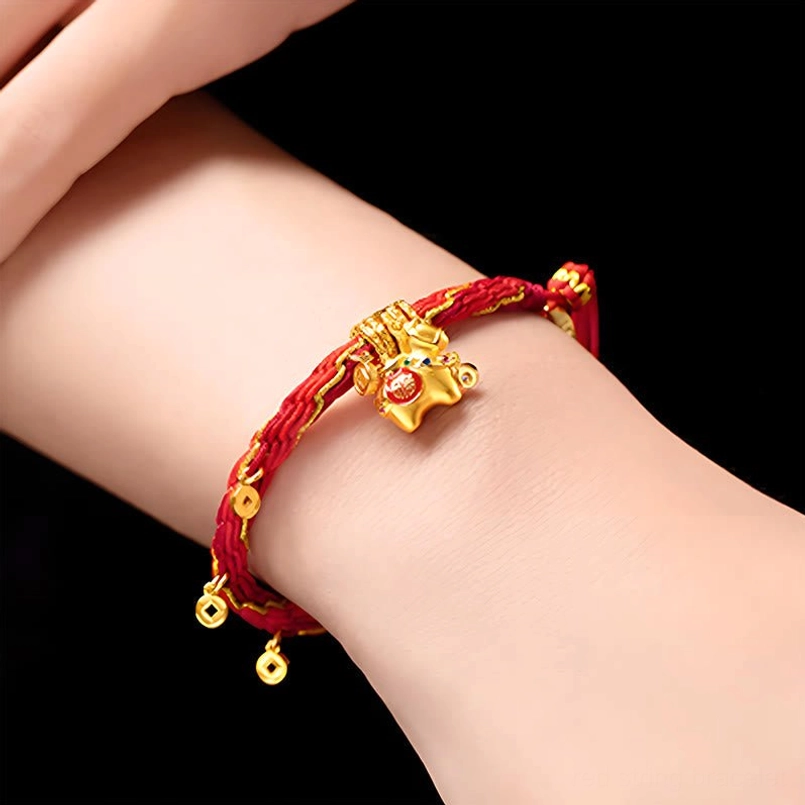 Close-up of worn Year of the Horse red string bracelet on wrist showing gold horse charm fixed on woven red cord