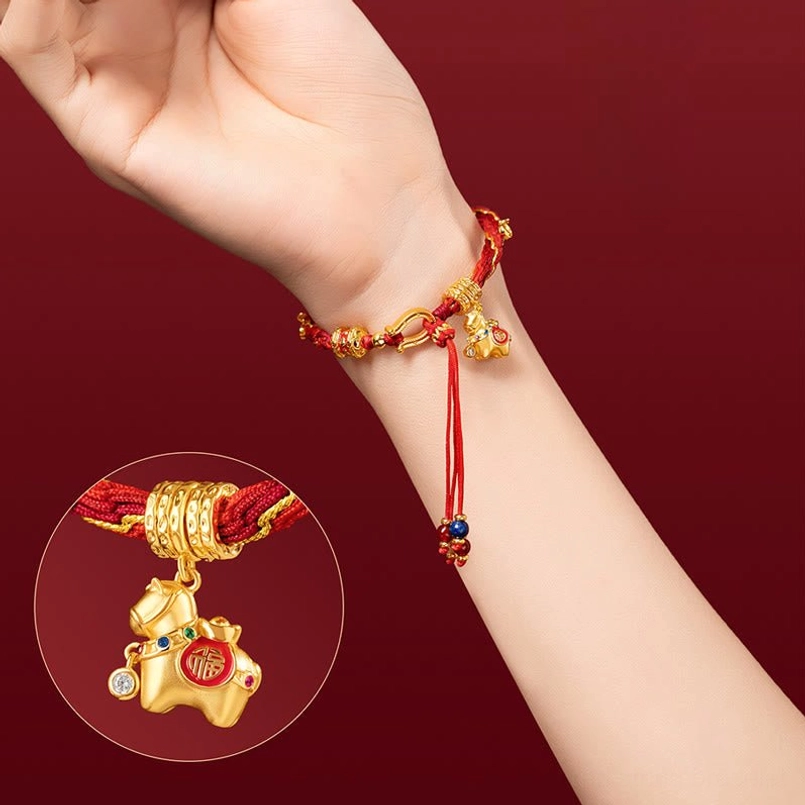 Worn red luck bracelet on wrist with inset close-up detail of gold horse Fu charm and beaded tassel