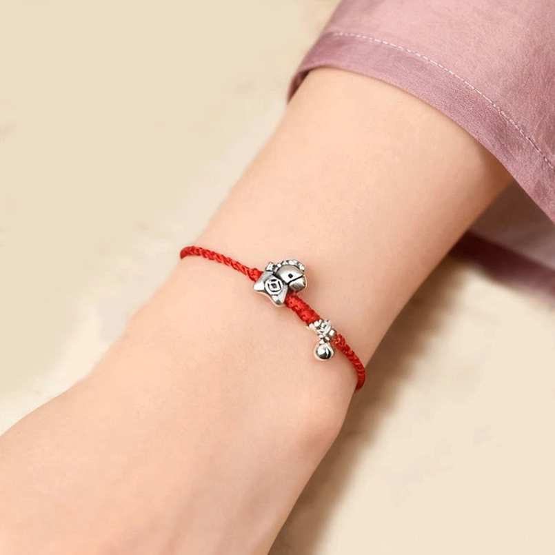 Red string anklet with Year of the Horse silver charm and bell on ankle lifestyle image