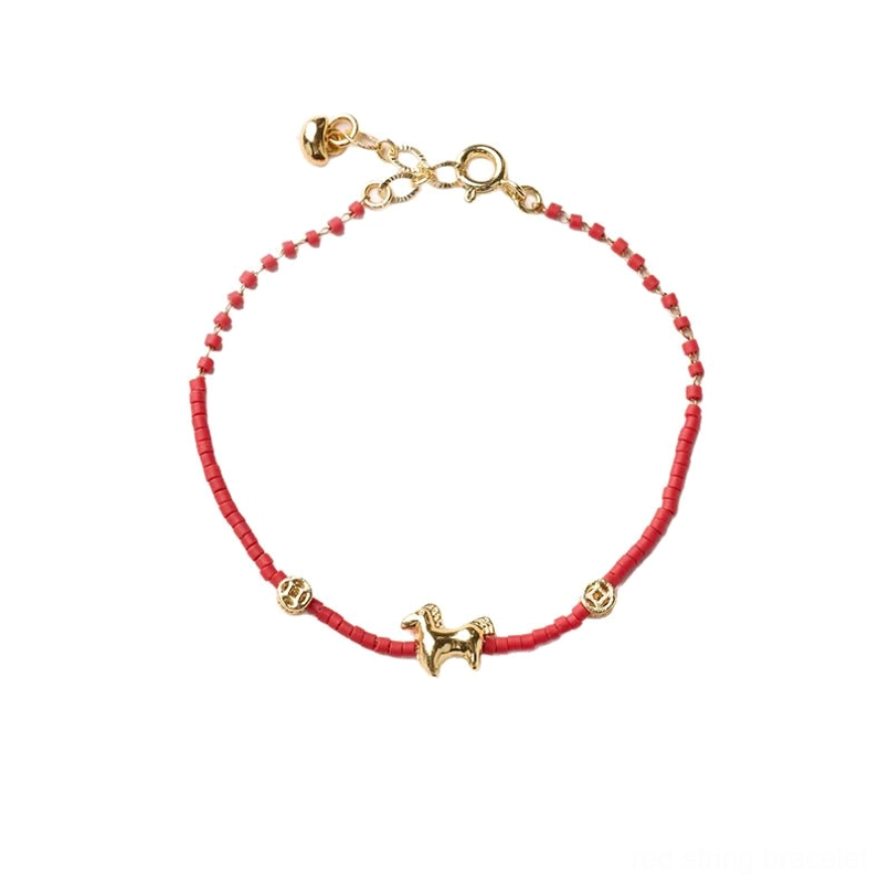 Full overhead view of completed red liuli glass horse bracelet with all charms on light background