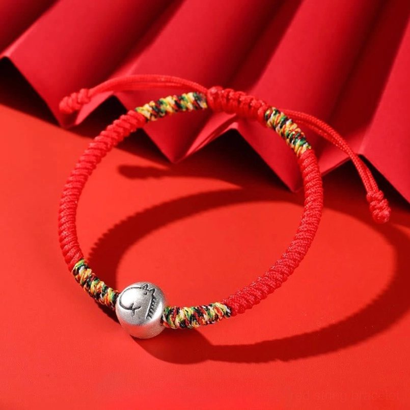 Zodiac Horse red string bracelet top view on red folded paper background
