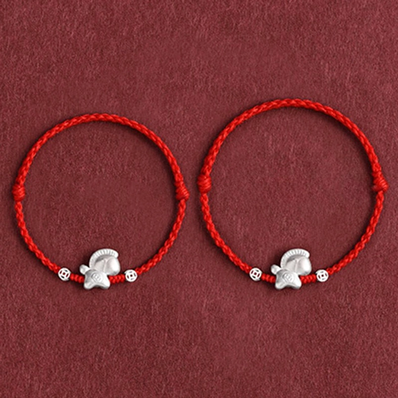 Wrist wear demonstration of Year of the Horse red string bracelet with sterling silver horse charm in natural light