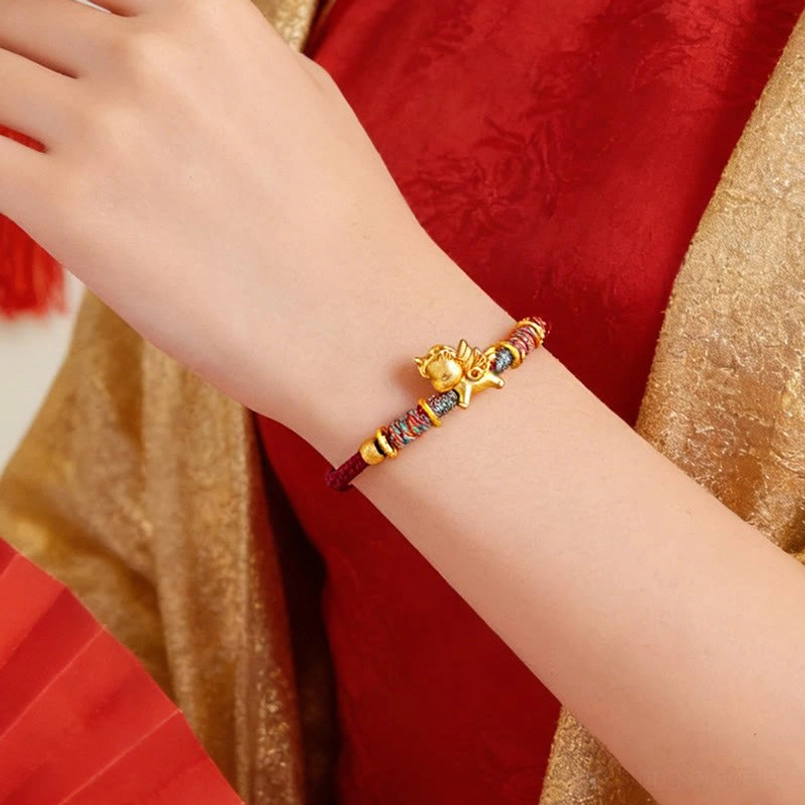 Red string horse charm bracelet worn on wrist close up