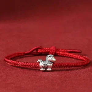 Year of the Horse 999 sterling silver red string bracelet with horse charm and ancient coin design on dark red background