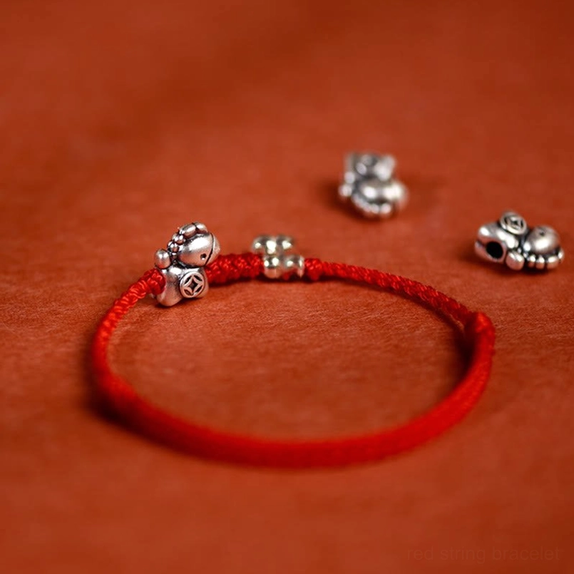 Year of the Horse red string bracelet with silver horse motif and bell accent side close-up